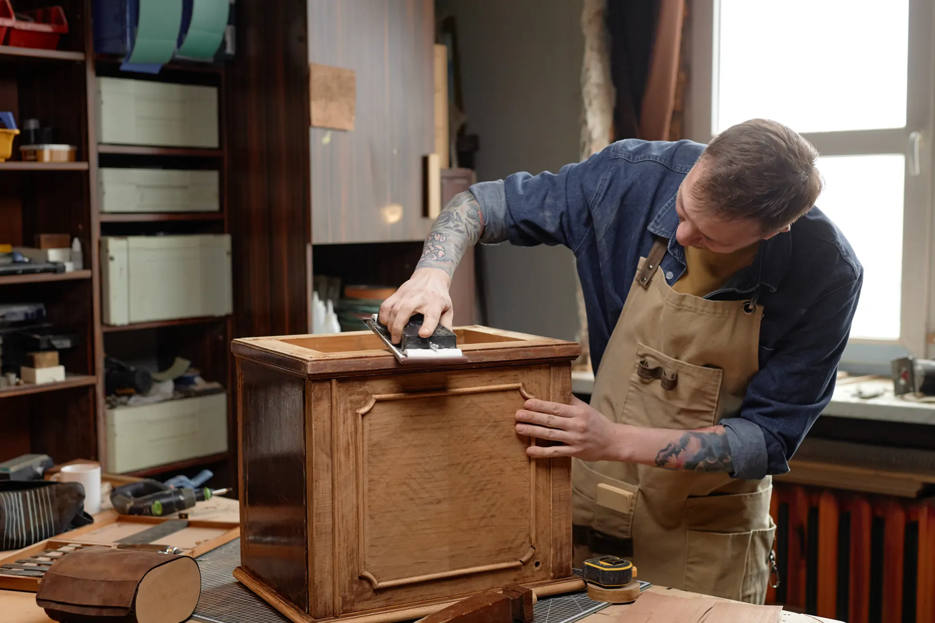 Artisan ponçant une boîte en bois dans son atelier