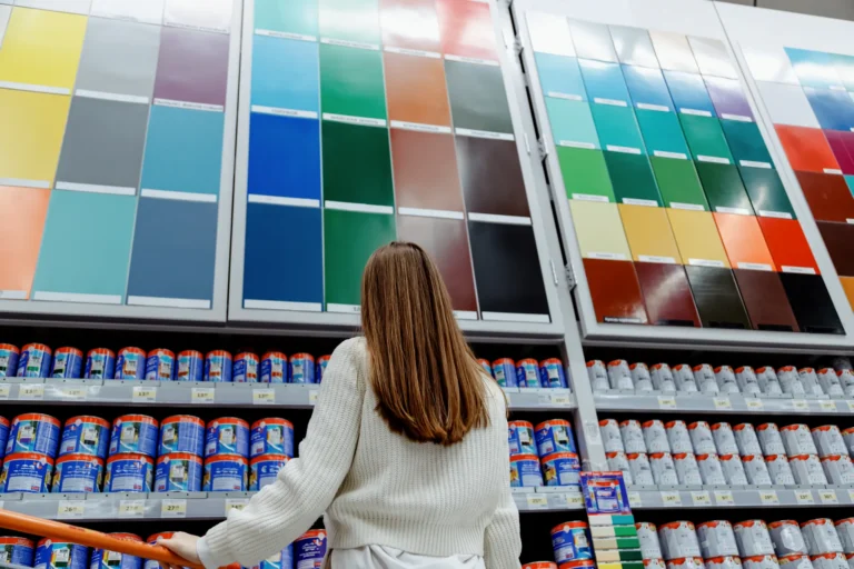 Cliente devant un mur de nuanciers de peinture en magasin
