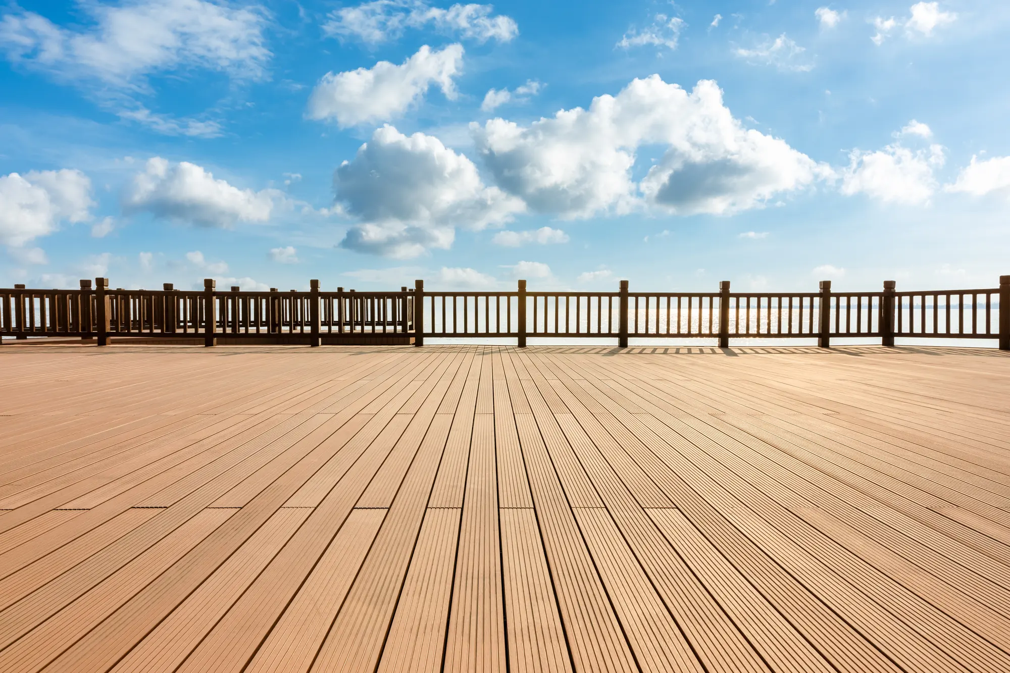 Terrasse en bois face à l'océan sous un ciel bleu